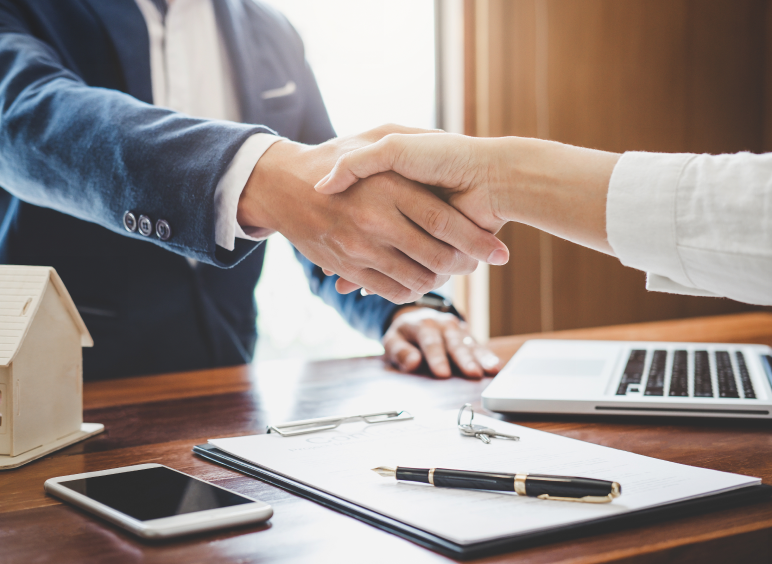 Two people shaking hands in meeting